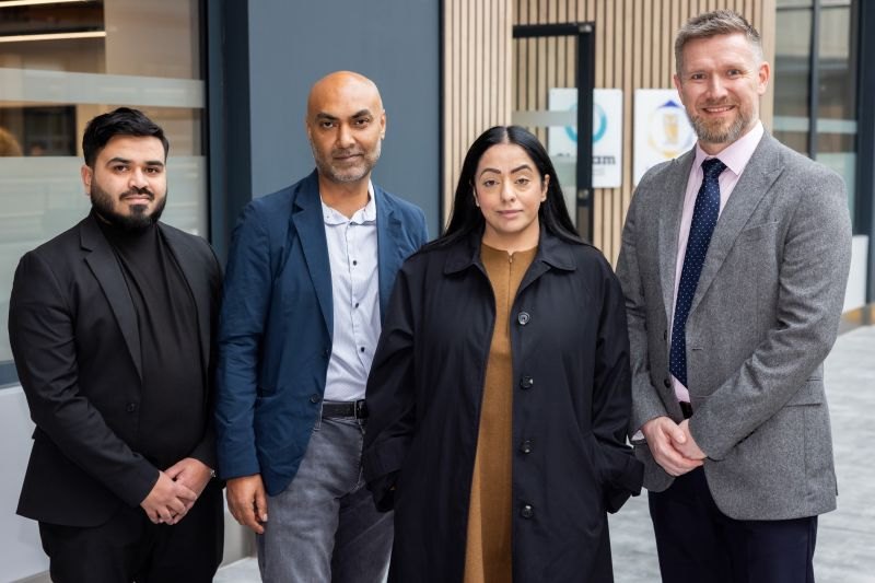 Four people standing together outside a building at the launch of the Oldham Trading Platform